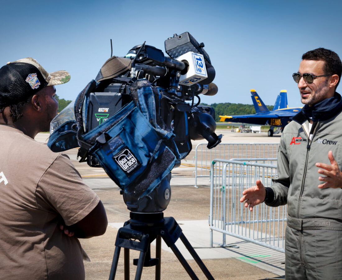 Australian aerobatic champion Aarron Deliu talks with a local television station at the 2024 Oceana Airshow in Virginia Beach, Virginia.